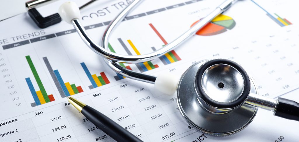 Stethoscope and pen laying on printed HEDIS® data charts.